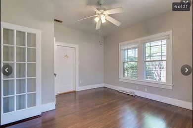 Empty room with a ceiling fan, wood finished floo