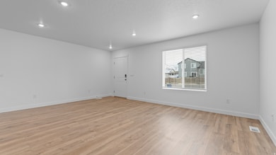 Unfurnished room featuring light wood-style floors, recessed lighting, and a textured ceiling