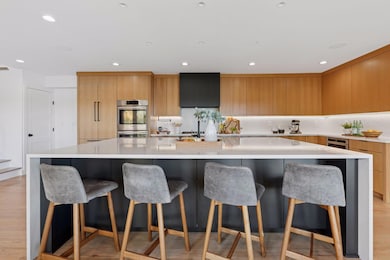 Warm oak cabinetry pairs beautifully with clean modern lines and quartz counters.