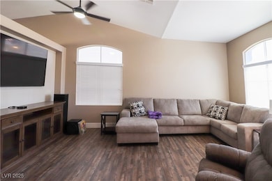 Living area with ceiling fan, dark wood-type floor