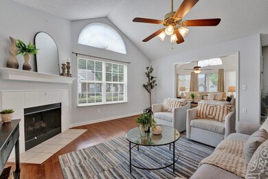 Living room featuring light wood-type flooring, plenty of natural light, and ceiling fan