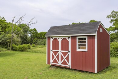 Two of these charming out buildings stay with the home. Complete with flourishing raised gardens between them