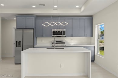 Kitchen with light stone countertops, appliances w
