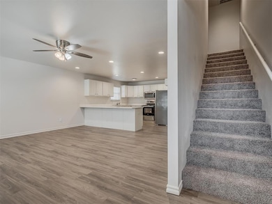 Stairs featuring light hardwood / wood-style floors, sink, and ceiling fan