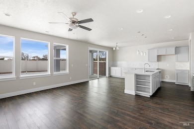 Unfurnished living room with dark wood-style floors, a ceiling fan, a textured ceiling, and recessed lighting