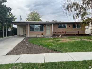 Single story home with brick siding, concrete driveway, and an attached carport