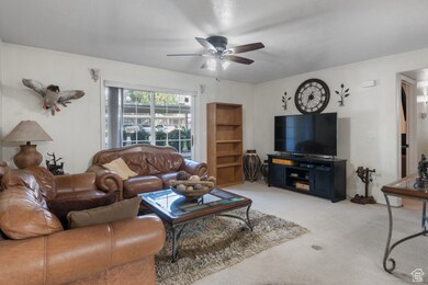 Carpeted living room with ceiling fan