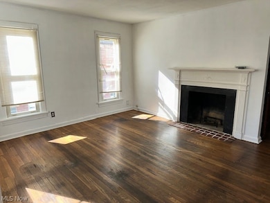 Unfurnished living room featuring dark hardwood / wood-style flooring and a tiled fireplace