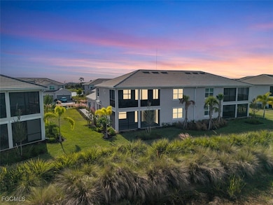 Back of property at dusk with a lawn, a sunroom, and stucco siding