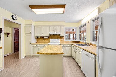 Kitchen with white appliances, wooden counters, un