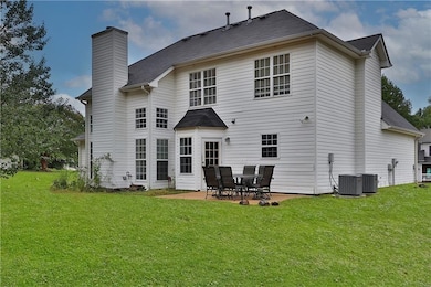 Back of property with a patio area, a lawn, and a chimney