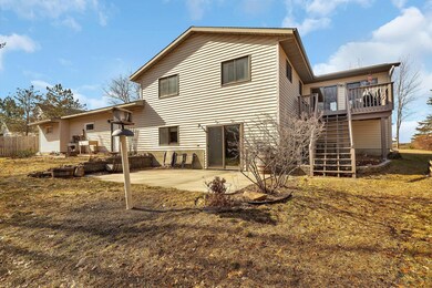 Patio and deck overlook wooded back yard with walking path to creek
