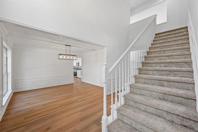 Foyer with a towering ceiling and light wood-type 
