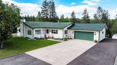 Ranch-style home with roof with shingles, driveway, an attached garage, a chimney, and a front lawn