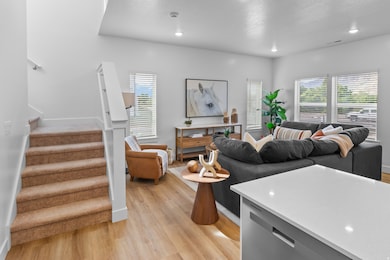 Living area with stairway, light wood-style flooring, a textured ceiling, and recessed lighting