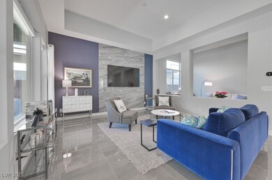 Tiled living room featuring a raised ceiling and baseboards