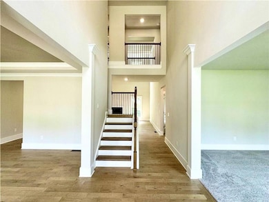 Stairs featuring baseboards, a high ceiling, and w