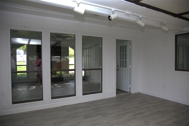 Unfurnished living room featuring brick wall, a healthy amount of sunlight, a brick fireplace, and light wood-type flooring