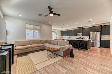 Living area featuring light wood-style flooring, recessed lighting, and ceiling fan