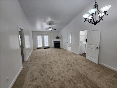 Single story home featuring an attached garage, driveway, a front lawn, and roof with shingles