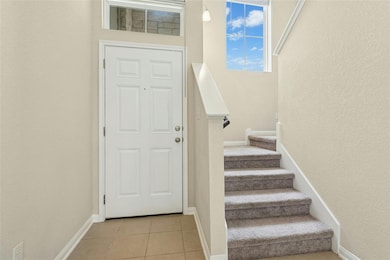 Foyer featuring stairway, baseboards, light tile 