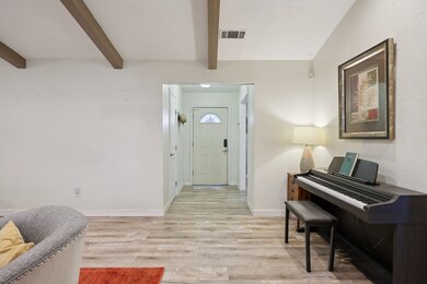 Entryway featuring light wood-type flooring and beamed ceiling