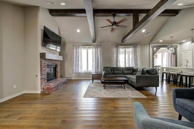 Living room featuring a brick fireplace, lofted ce