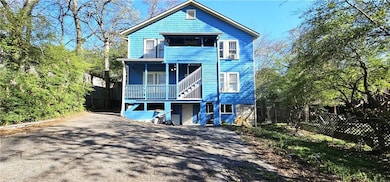View of front of home featuring fence, asphalt driveway, and covered porch