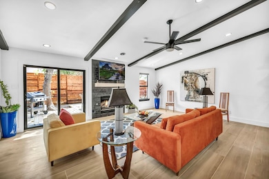 Living room featuring healthy amount of natural light, light wood-style floors, a fireplace, recessed lighting, and a ceiling fan