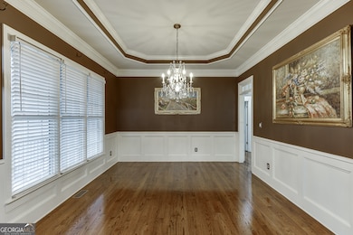 Formal dining room with elegant trim and large windows for natural light.