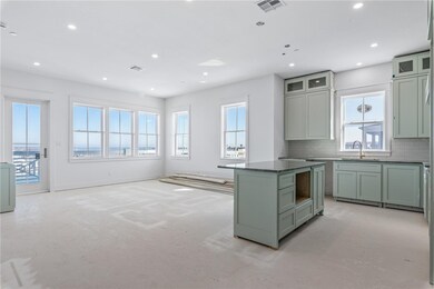 Tall windows flood the living area, adjoining kitc