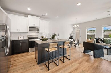 Kitchen featuring stainless steel appliances, recessed lighting, white cabinets, backsplash, and a breakfast bar