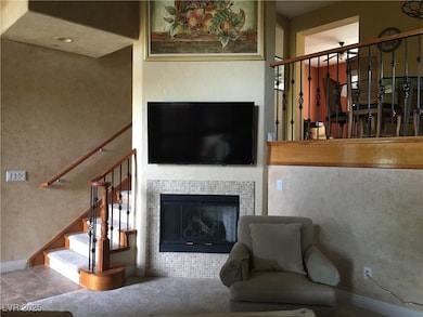 Living area with stairs and a tile fireplace