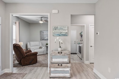 Living room with ceiling fan and light wood-type flooring