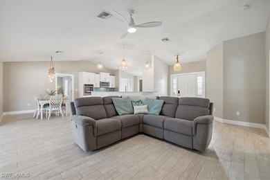 Living area with light wood-style floors, vaulted