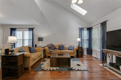 Hardwood floored living room with lofted ceiling w