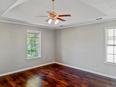 Bright, expansive master bedroom features coffered