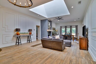 Living room with ceiling fan with notable chandeli