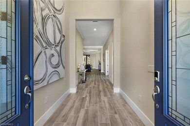 Foyer entrance with wood-type flooring and ornamental molding