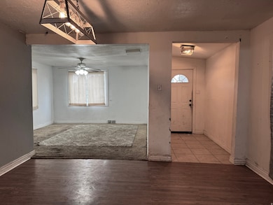 Foyer with a textured ceiling, wood finished floors, and a ceiling fan