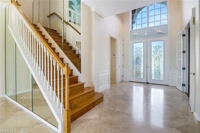 Foyer featuring a towering ceiling, light tile pat