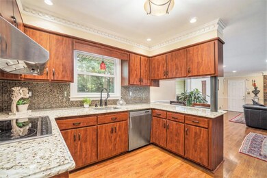 The Kitchen is the Heart of the Home, featuring Rich Stained Cabinets, Granite Countertops, Stainless Steel Appliances, and a Seamless Flow into the Family and Dining Rooms