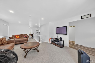 Carpeted living area with recessed lighting