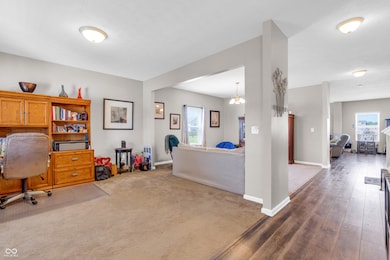 home office with plenty of natural light, a chandelier, and dark wood-type flooring