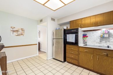 Kitchen includes flat top stove and great backsplash.