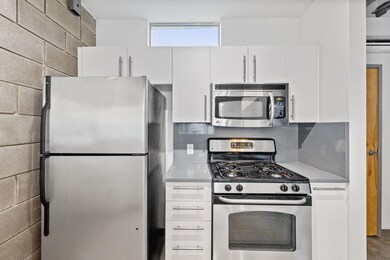 Kitchen with light countertops, white cabinets, s