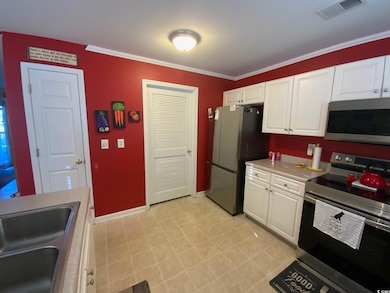 Kitchen with white cabinets, appliances with stain