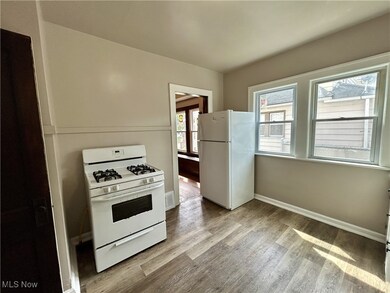 Kitchen with white appliances and light hardwood / wood-style flooring