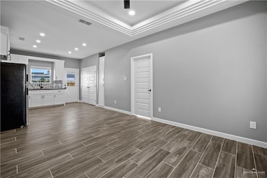 Unfurnished living room featuring recessed lighting, baseboards, dark wood-style floors, and visible vents