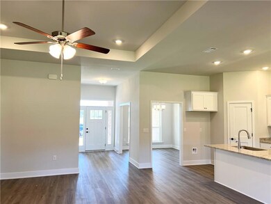 Kitchen with white cabinets, light stone countertops, dark wood-style flooring, a chandelier, and recessed lighting